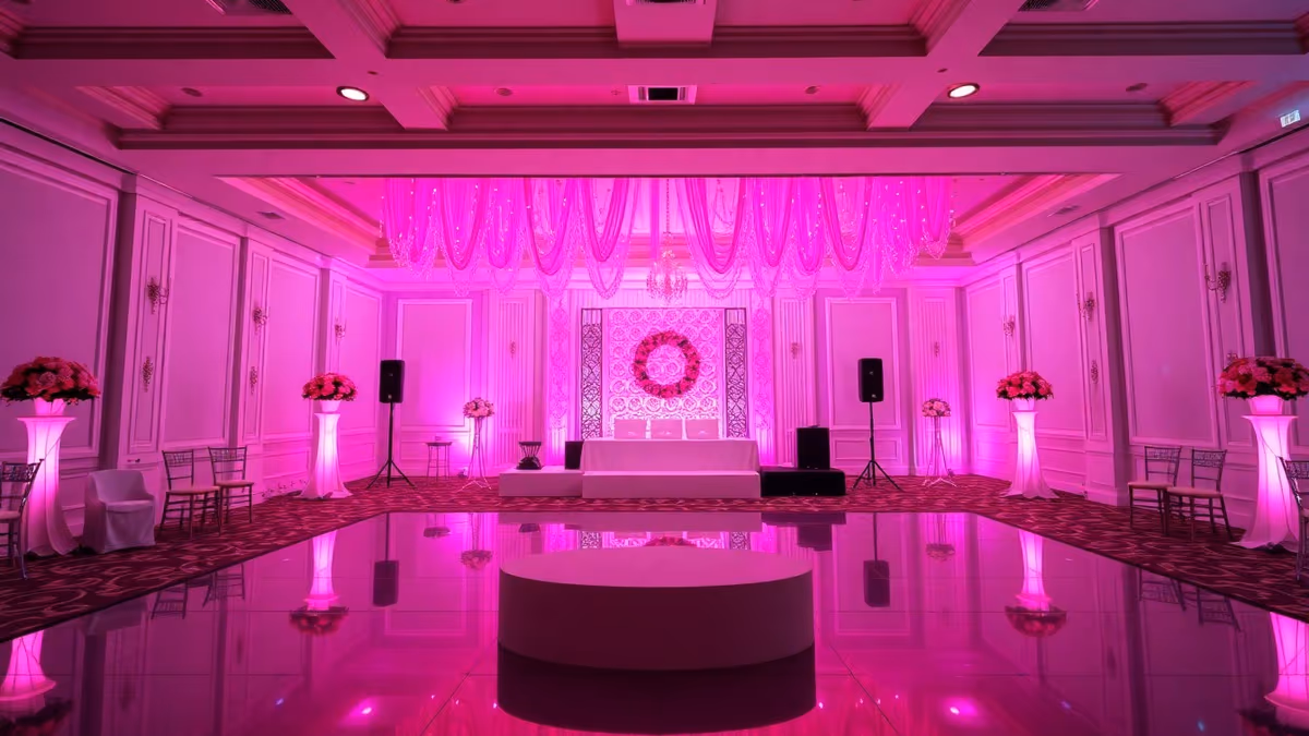 Salón de XV años con los muros bañados de color magenta por reflectores par LED
